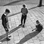 848117 Afbeelding van drie kinderen die op straat aan het knikkeren zijn, vermoedelijk in Amsterdam-West.